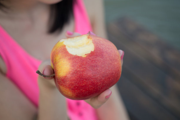 美丽的女孩正在吃新鲜的苹果图片下载