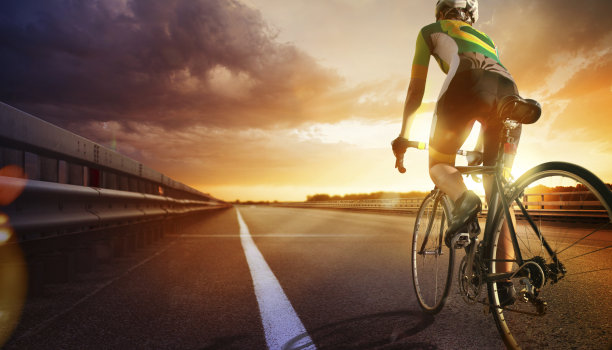 骑自行车的人在高速公路上骑着自行车去夕阳图片下载