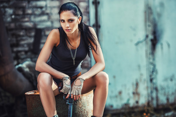 性感野蛮的女人坐着，拿着手枪图片下载