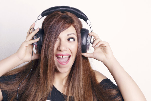 戴着耳机玩得开心的女人。图片下载