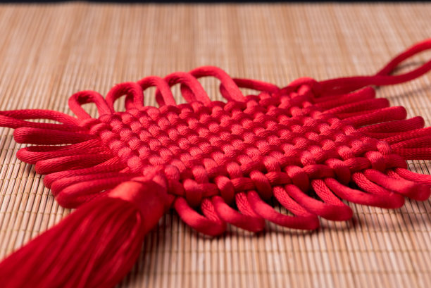 竹席上的红色中国结细节素材图片