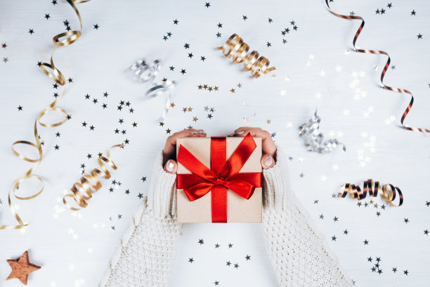 女性手握礼品，红色蝴蝶结素材图片