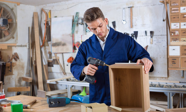 男工人对钻抽屉进行整理素材图片