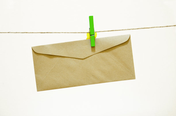 棕色的信封挂在绿色的衣服别针上图片下载