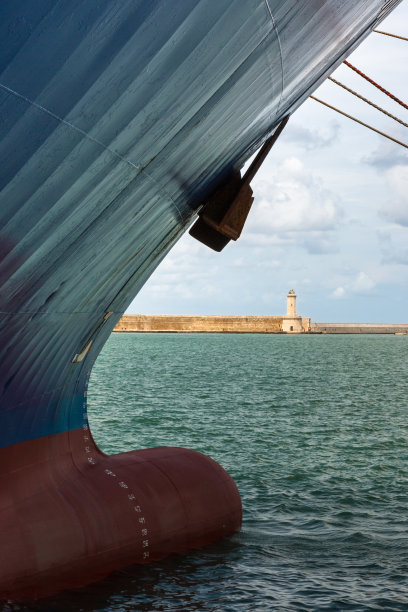 码头上的船头和绳索，背景是白色灯塔图片下载