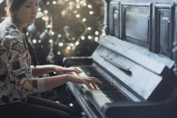 女孩弹钢琴，近距离，黑白键盘图片下载