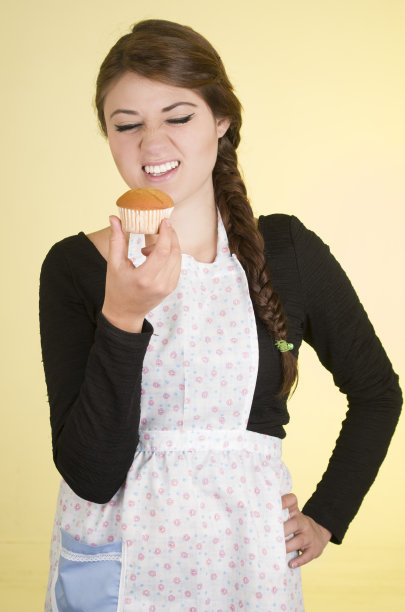 年轻漂亮的女厨师，厨师，面包师，穿着围裙图片下载