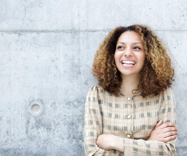 抱着双臂在户外微笑的女人图片下载