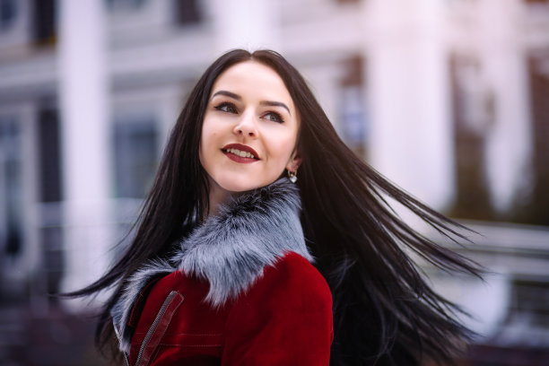 城里年轻美丽的模特。充满活力的年轻女孩走在街上。头发在风中飘扬。图片下载