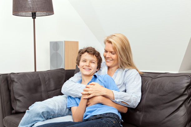 母亲和儿子坐在沙发上图片下载