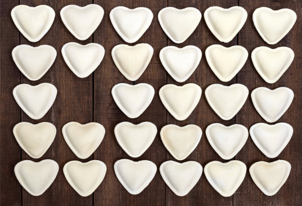 生的心型生面团(饺子、意大利饺子、意大利饺子)，排成一排图片下载