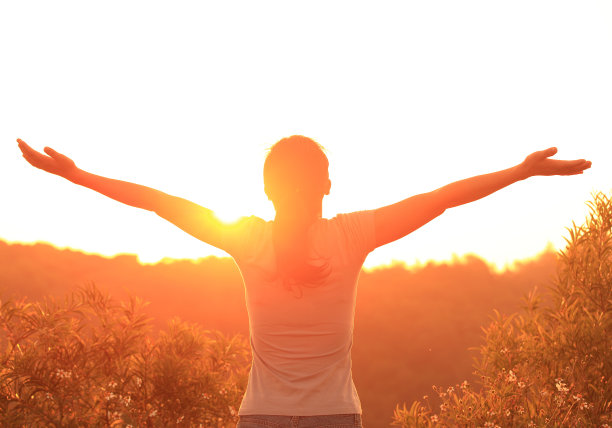 女人举起双臂迎接日出图片下载