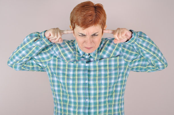 皱眉的女人用她的食指捂着耳朵图片下载