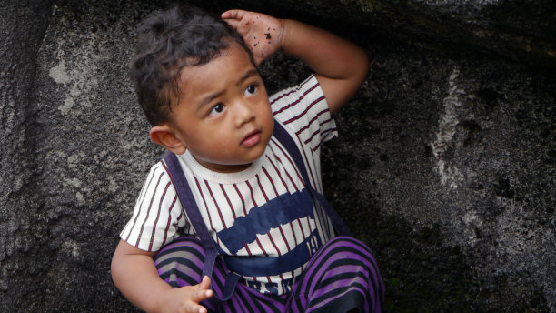 男孩在岩石上玩耍图片下载