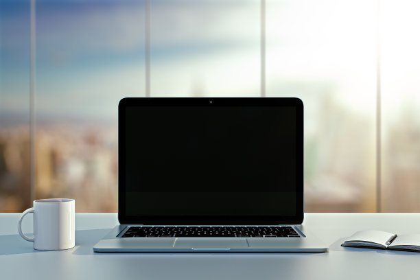 笔记本电脑，杯子和日记本放在办公室的桌子上图片下载