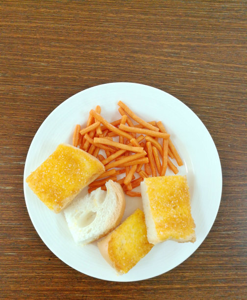 白色盘子里的脆皮小吃。零食盘放在木制的背景上。在图片的顶部复制空间。图片下载