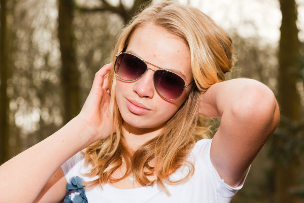 秋天的森林里戴着墨镜的漂亮女孩。时尚风格的照片。图片下载