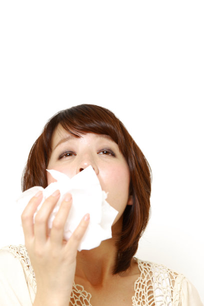 有过敏症的年轻女子对着纸巾打喷嚏图片下载