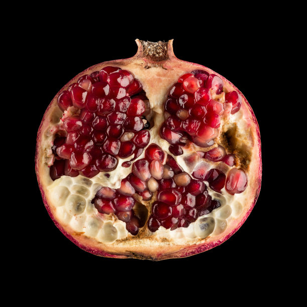 一半的石榴放在黑色的上面图片下载