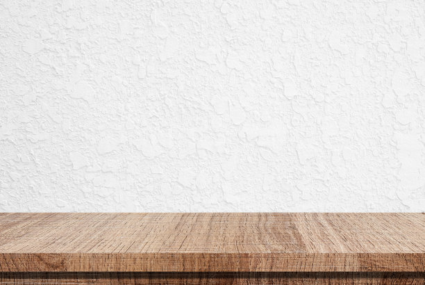 白色水泥墙背景上的空木桌图片下载