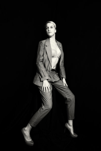 黑色背景下穿着西装和胸罩的年轻女子图片下载