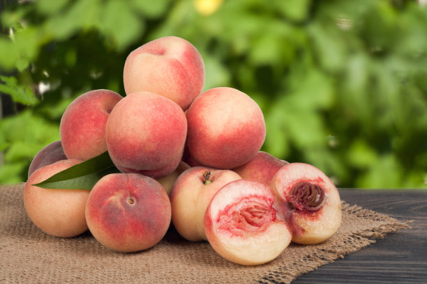 背景模糊的木桌上放着一堆桃子图片下载