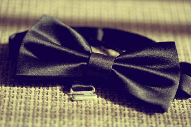 黑色领结礼服在织物桌上图片下载