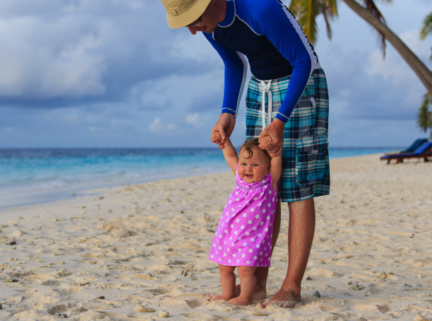 爸爸和小女儿在海滩上散步图片下载