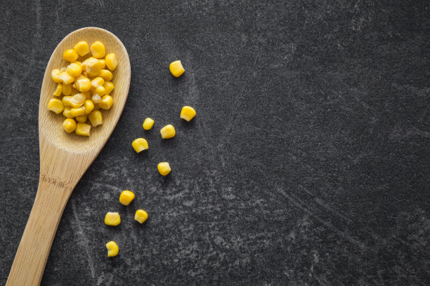 木勺里装着罐头玉米。健康的饮食和生活方式。素材图片