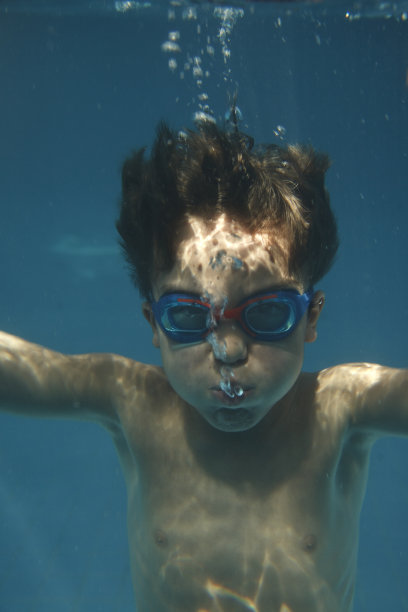 孩子在游泳池里游泳。图片下载