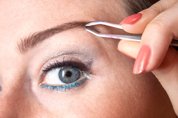 用镊子拔眉毛的女人图片下载