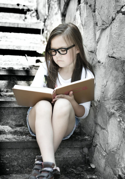 小女孩正在户外读书图片下载