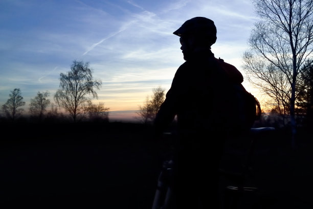 日落时分，山地自行车手在山道上骑行图片下载