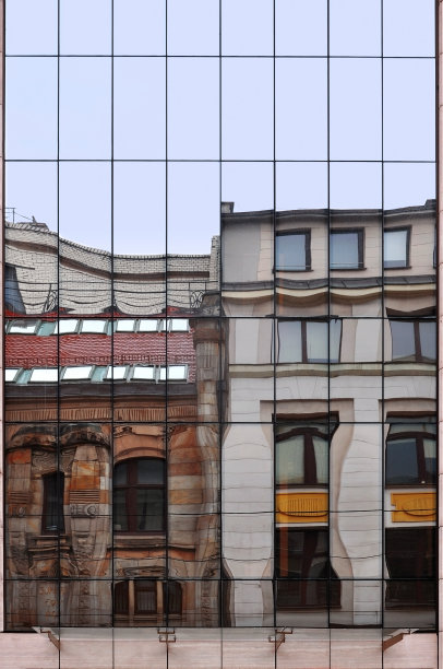 建筑在现代住宅的玻璃墙中扭曲的反射。图片下载