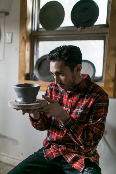 陶工在检查一只完成的碗图片下载