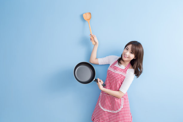 家庭主妇拿着炒锅和勺子素材图片
