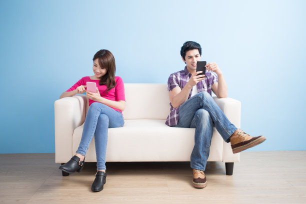 年轻夫妇愉快地玩手机图片下载