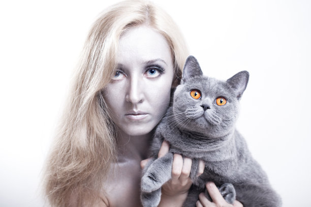 带着一只灰色英国猫的年轻女子图片下载