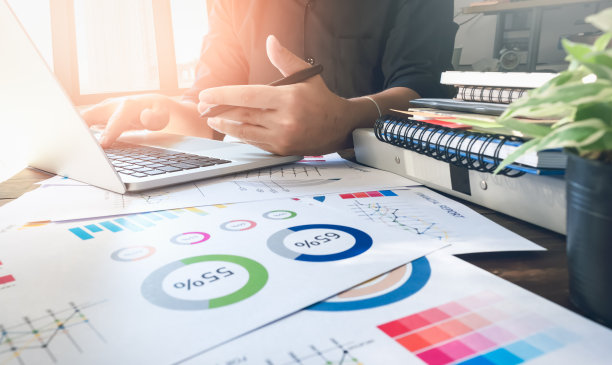 柔和的焦点商人手工作笔记本电脑在办公室的木桌在晨光。复古的效果图片下载