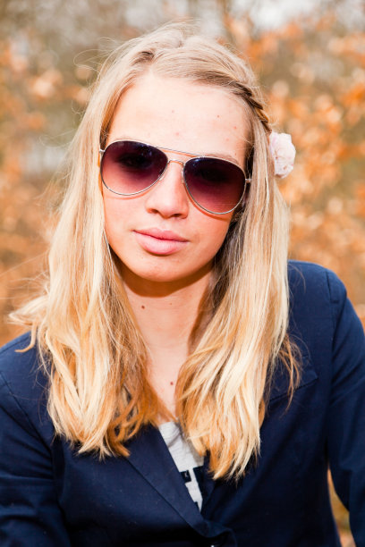 秋天的森林里戴着墨镜的漂亮女孩。时尚风格的照片。图片下载
