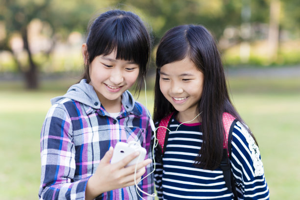 两个少女朋友在学校看智能手机图片下载