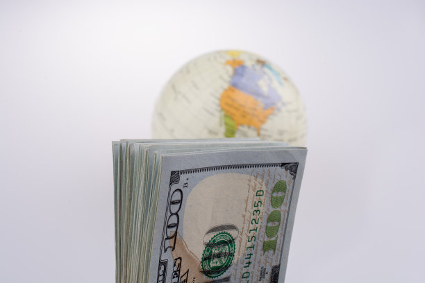 在一个地球仪模型旁边放着美钞图片下载