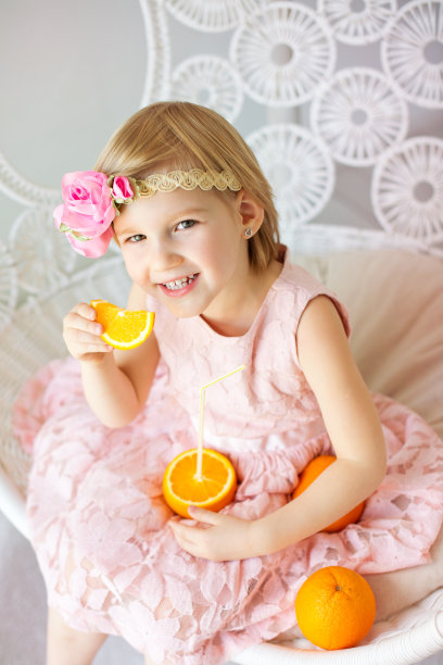 快乐的孩子拿着橘子图片下载