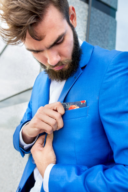 留着胡子的商人正在整理西装上的手帕。图片下载