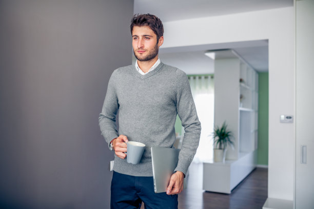 英俊年轻微笑的商人在家工作图片下载