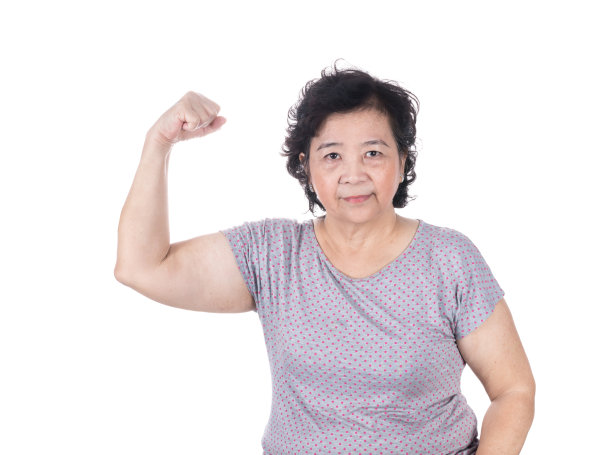 强壮的亚洲资深女性展示她的二头肌收缩肌肉图片下载