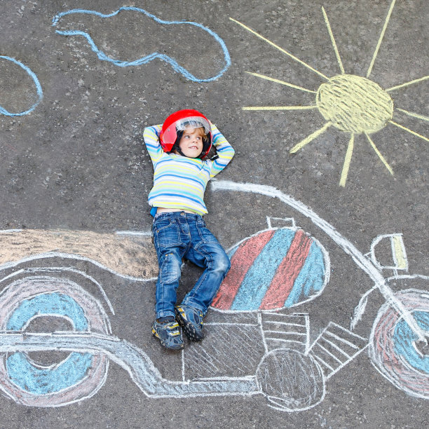 小孩子戴着头盔，骑着摩托车，画着彩色的图画图片下载