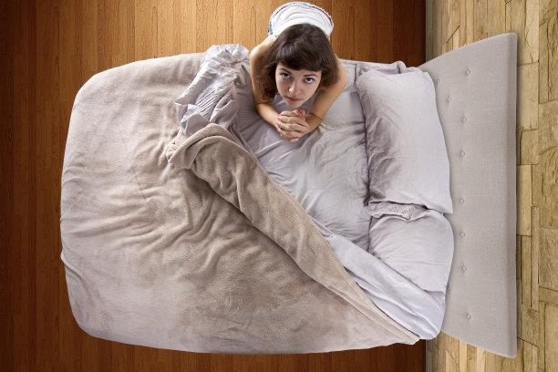 俯视图的年轻女子祈祷在卧室图片下载