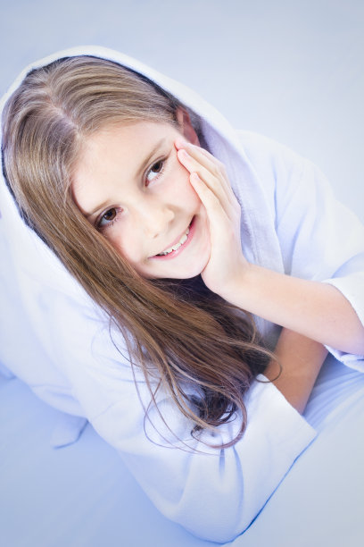 快乐的小女孩躺在床上图片下载