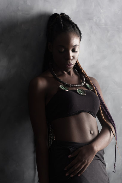 非洲女孩，有长长的民族辫子和裸露的肚子图片下载